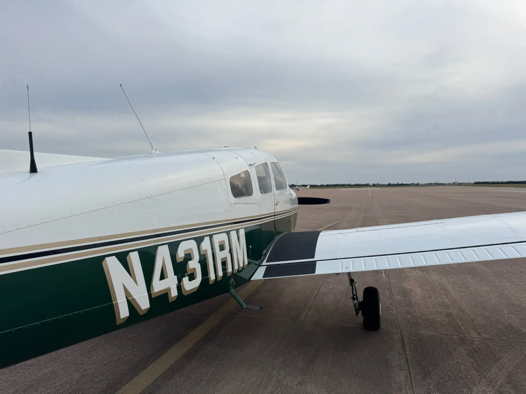 Close view of the N431RM registration on the right side of the fuselage, with the wing walkway and right main landing gear.