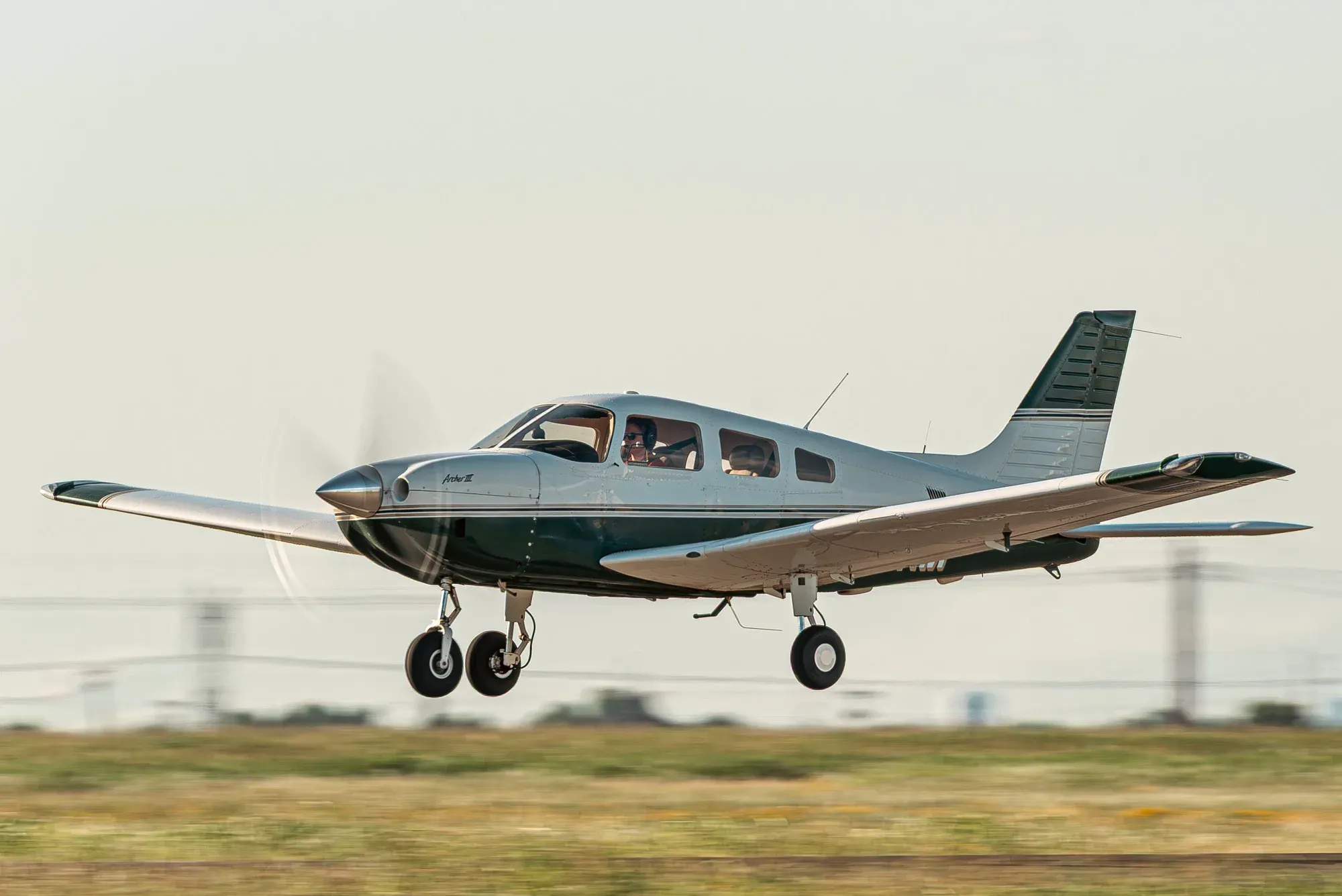 N431RM just after liftoff, seen from the front left with the landing gear extended, the propeller spinning and the pilot visible in the cockpit.